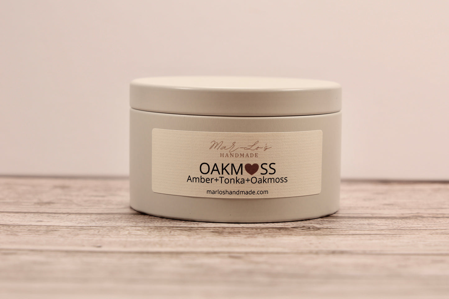 5.5 oz Oakmoss candle tin with wooden wick and clean-burning coconut apricot wax in a reusable metal container; fresh, citrusy, and earthy scent.