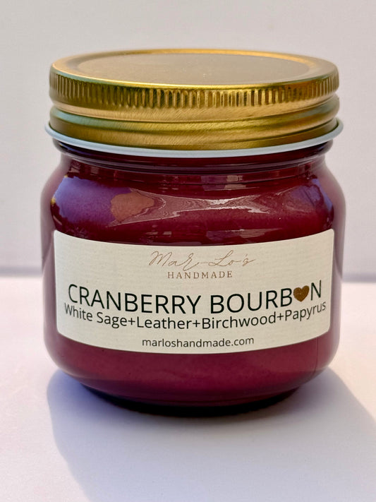 Cranberry Bourbon candle in cranberry colored mason jar with gold lid and wooden wick